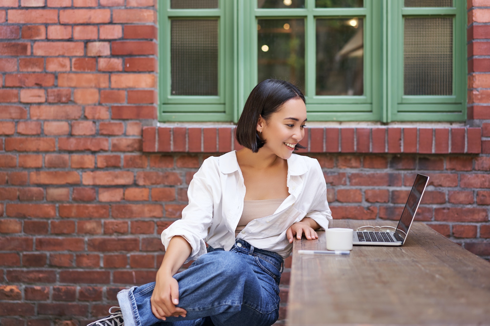 portrait-of-young-stylish-woman-influencer-sitting-in-cafe-with-cup-of-coffee-and-laptop-smiling.jpg